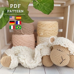 Puede incluir: Un patrón de ganchillo en PDF que muestra un juguete de oveja de peluche con cara beige y cuerpo de lana blanca texturizada. La imagen incluye el texto PDF PATTERN, seis banderas nacionales y cuatro ovillos de lana beige y crema detrás.