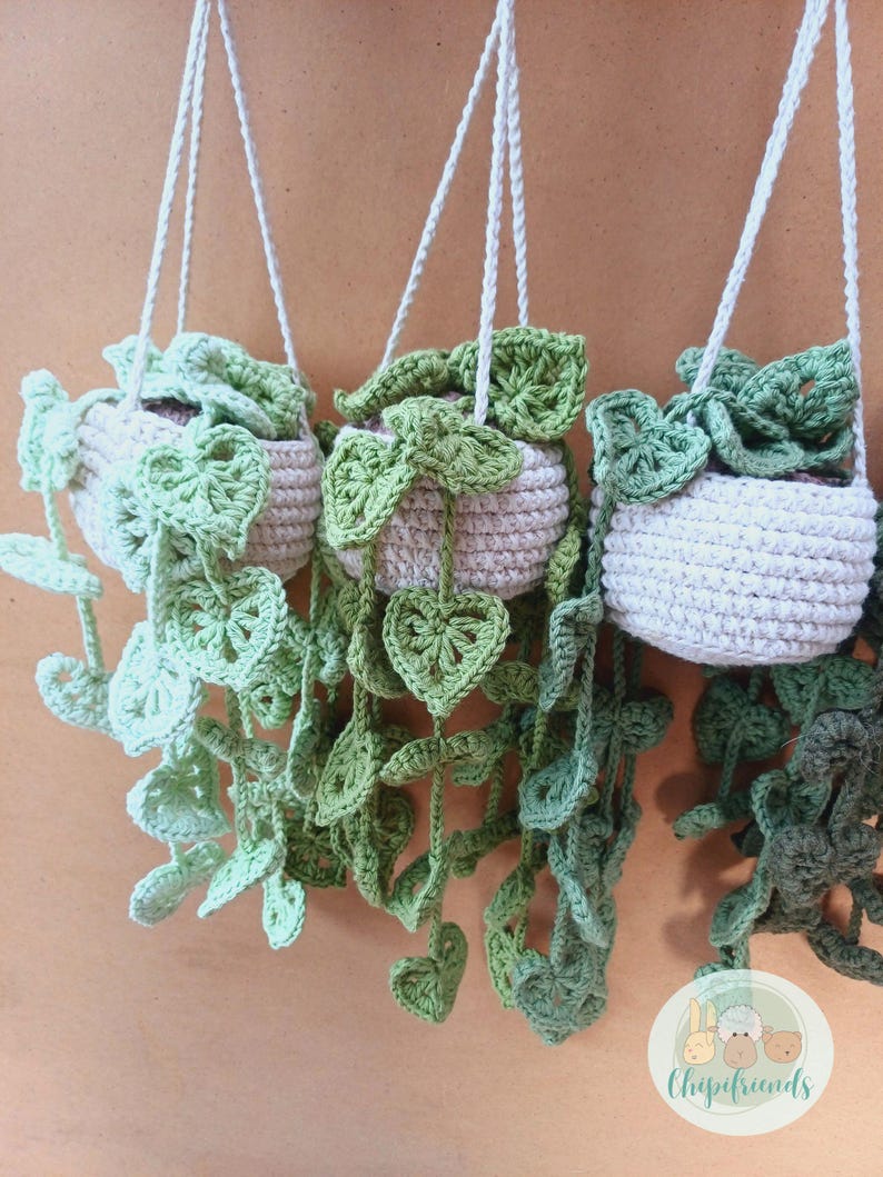 May include: Three crocheted hanging planters with green leaves and a white pot. The planters are hanging from white cords. The image includes the text "Chipifriends" in a white font with a green background.