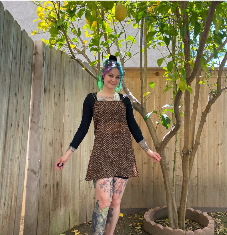 1990’s sheer mini dress. Brown with light brown flowers all over. Pull over style, no zipper. Fits like XS