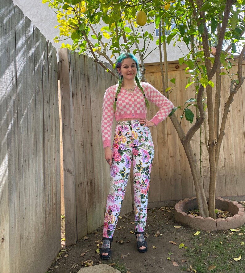 1990s white denim jeans with pink, purple and yellow floral print all over. High waisted skinny jeans with loops at the bottom of the legs for your feet. Size XS/ Small.