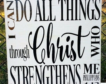 May include: White wooden sign with black text that reads "I can do all things through Christ who strengthens me Philippians 4:13".