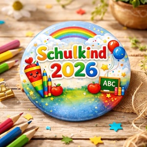 Op de afbeelding: Een ronde, kleurrijke illustratie met de tekst "Schulkind 2026" en een regenboog. Het ontwerp bevat een cartoon schooltuit, potloden, appels, ballonnen en een schoolbord met "ABC". De achtergrond is een blauwe hemel met sterren.