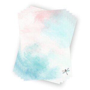 Peut inclure: Une pile de papier &agrave; lettres vierge avec un fond aquarelle dans des tons de rose et de bleu. Une libellule est imprim&eacute;e dans le coin inf&eacute;rieur droit.