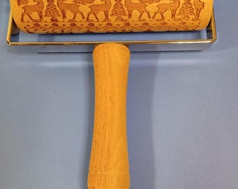 以下が含まれることがあります： トナカイと松の木の模様が刻印された木製の麺棒。シリンダーは銀色の金属フレームに取り付けられており、中央から伸びる滑らかな明るい色の木製ハンドルで手動で回転させて使用できるようになっています。