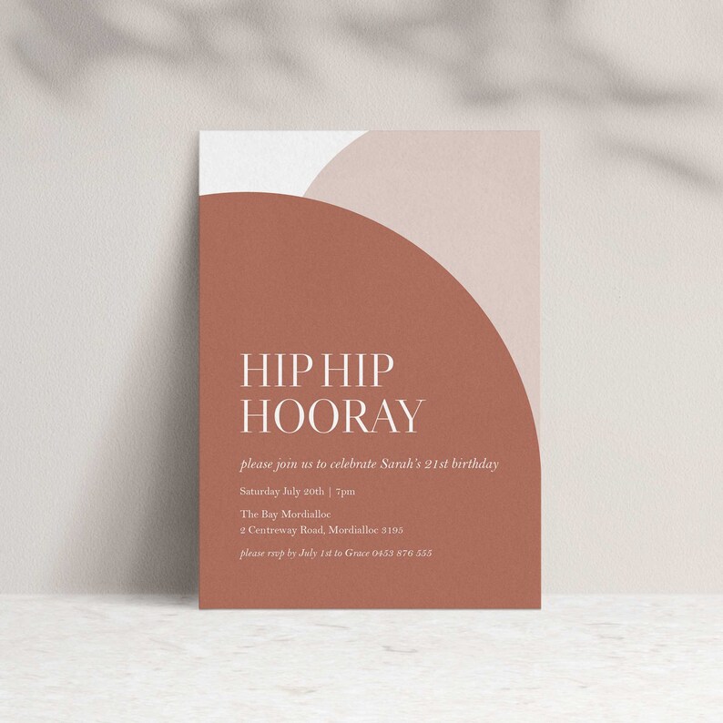 Puede incluir: Una tarjeta de invitaci&oacute;n rectangular con un dise&ntilde;o de semic&iacute;rculo de color terracota y las palabras "HIP HIP HOORAY" en blanco. La tarjeta incluye detalles para el 21 cumplea&ntilde;os de Sarah, como la fecha, la hora y el lugar.