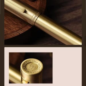 Puede incluir: Primer plano de una pluma estilogr&aacute;fica dorada. El bol&iacute;grafo tiene un acabado met&aacute;lico elegante con un anillo que dice "LF HongDian". La tapa del bol&iacute;grafo presenta el texto "BLACK FOREST 1861 HONG DIAN".