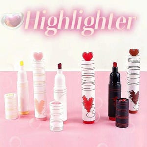 May include: A collection of decorative highlighters with heart-shaped toppers and heart designs. The highlighters are white with red, pink, and black accents. The word "Highlighter" is displayed in pink text.