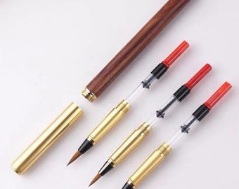 May include: A fountain pen set featuring a dark brown wooden barrel, a gold-toned metal cap, and three interchangeable ink converter cartridges. Each converter has a gold-toned metal grip section, a clear plastic ink reservoir, and a red plastic plunger.