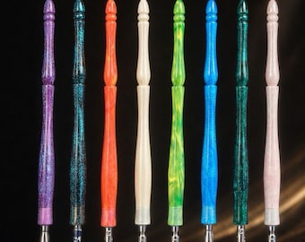 May include: Eight dip pens with turned acrylic handles in a variety of colors including purple, teal, orange, cream, green, blue, dark green, and light pink. Each pen features a metallic nib at the bottom and a rounded, decorative finial at the top.