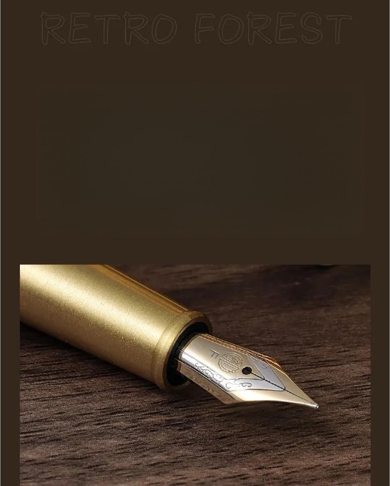 Puede incluir: Primer plano de una pluma estilogr&aacute;fica dorada con plum&iacute;n plateado. La pluma se encuentra sobre una superficie de madera marr&oacute;n oscuro. El texto "RETRO FOREST" est&aacute; en la parte superior.