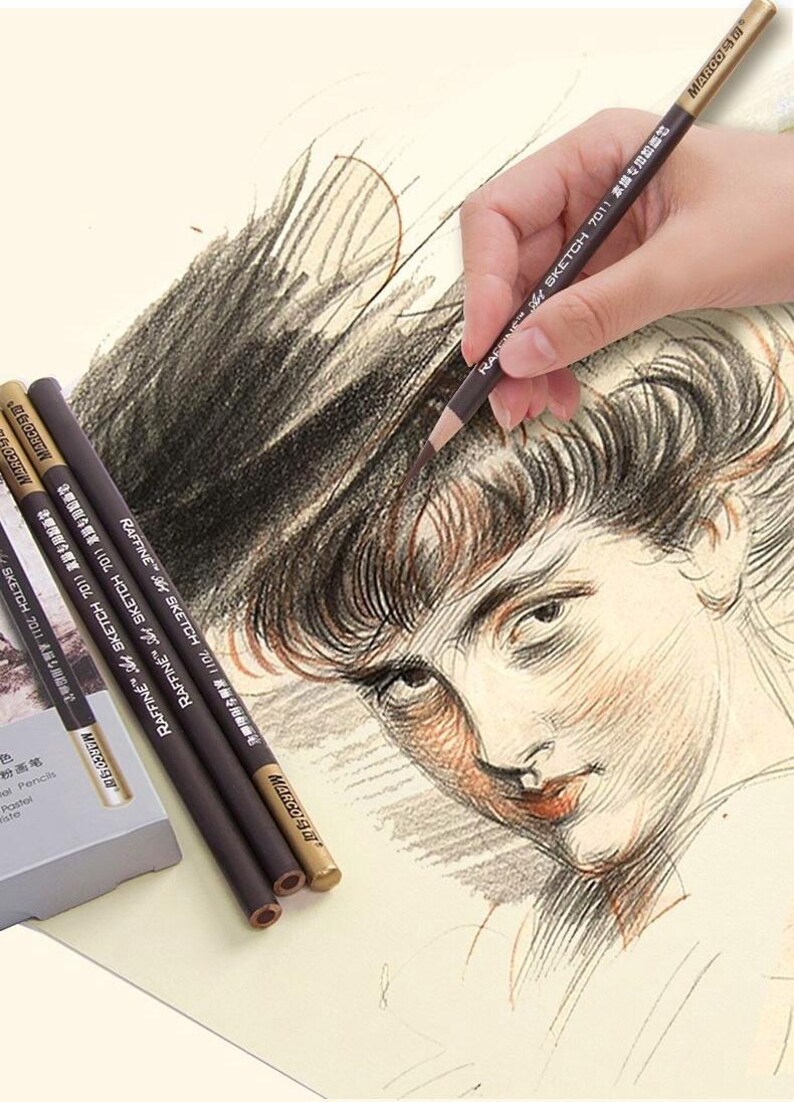 May include: A set of brown and gold coloured drawing pencils with the text "RAFFINE SKETCH 7011 素描专用粉笔" printed on the side. The pencils are on a white surface with a drawing of a person's face.