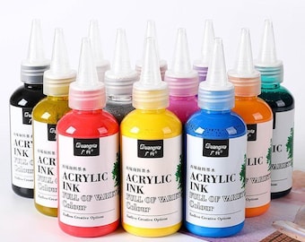 May include: A collection of twelve plastic squeeze bottles filled with various colors of acrylic ink. Each bottle features a white label with the text GuangNa, ACRYLIC INK, FULL OF VARIETY, and Endless Creative Options, topped with a clear nozzle cap.