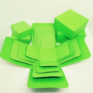 K&ouml;nnte beinhalten: Eine gr&uuml;ne Explosionsbox mit mehreren Schichten. Die Box ist aus Karton und zum Zusammenbauen gedacht. Die Box ist ge&ouml;ffnet und die Schichten sind sichtbar.