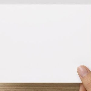 Puede incluir: Una tarjeta blanca en blanco con una esquina ligeramente doblada.