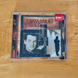 May include: A compact disc case featuring the album "Emmanuel Pahud" with the text "F.J. & J.M. Haydn Flute Concertos & Scherzandi." The cover includes a portrait of a man and a silhouette of a person. The EMI Classics logo is visible.