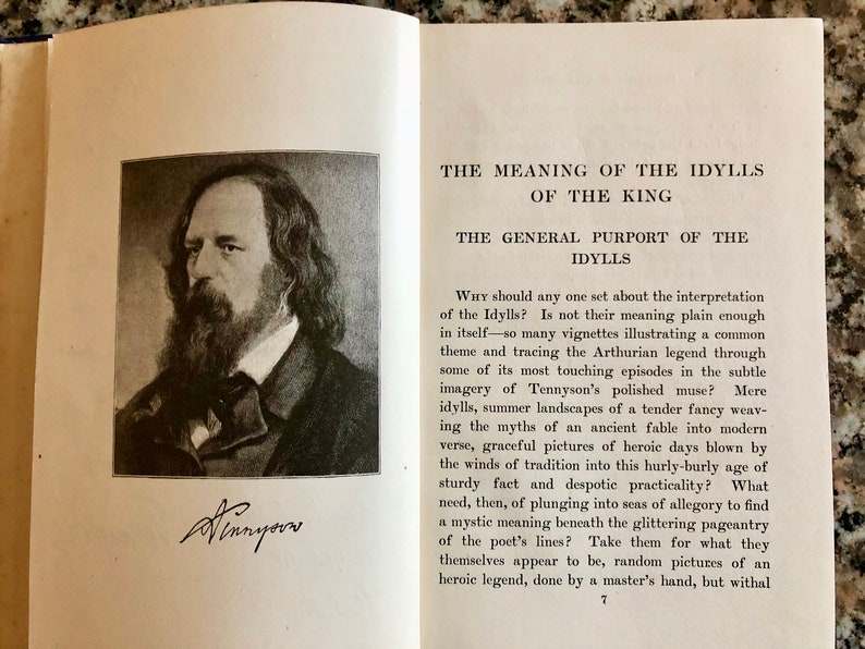 May include: A black and white portrait of Alfred, Lord Tennyson, the author of "Idylls of the King", with a signature below the image. The text above the image reads "The Meaning of the Idylls of the King" and "The General Purport of the Idylls".