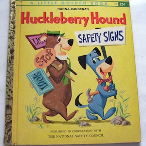 May include: A Little Golden Book titled "Huckleberry Hound" featuring Hanna-Barbera characters. The cover shows a brown bear and a blue dog holding signs that say "Stop", "Look", and "Safety Signs". The book is yellow with text in red and black.