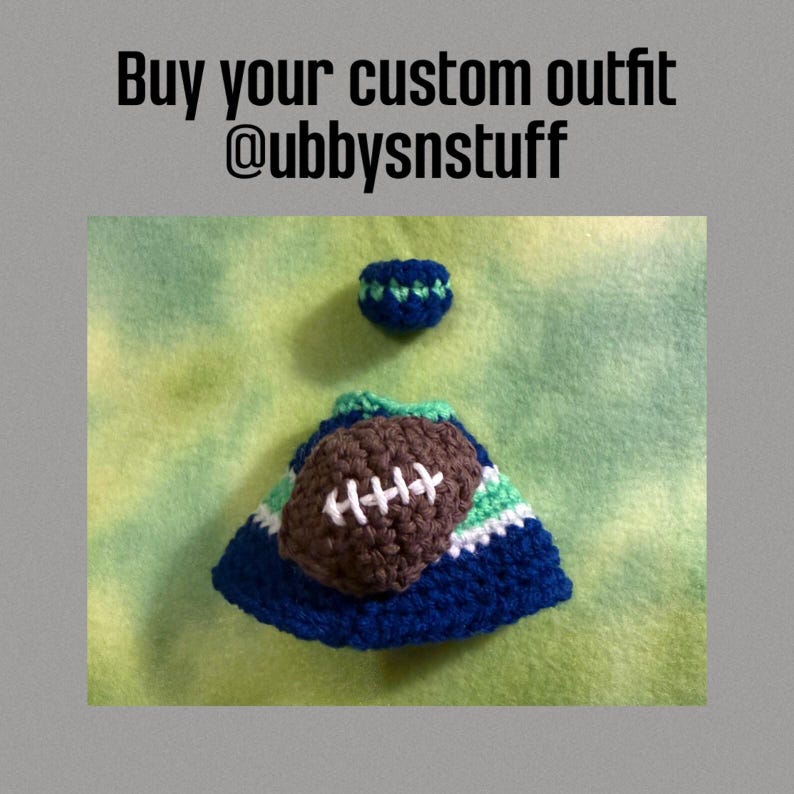 May include: A small crocheted blue, green, and white hat featuring a brown football applique with white stitching, accompanied by a matching blue and green crocheted ring. The text Buy your custom outfit @ubbysnstuff is visible above.