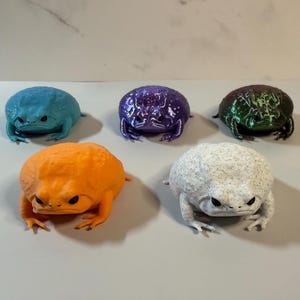 May include: A white ceramic mug with a black handle and the text "But First, Coffee" in a handwritten style. The mug is on a white surface. The mug is approximately 4 inches tall.