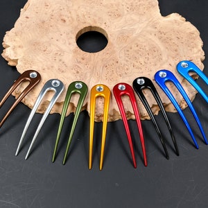 May include: Ten hair pins in various colors, including gold, silver, red, black, blue, and green. Each pin has a clear rhinestone at the top.