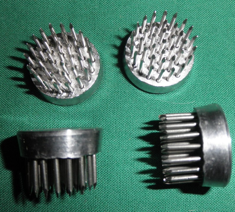 Peut inclure: Quatre supports en mousse florale argent&eacute;s avec des broches m&eacute;talliques pointues. Les supports sont circulaires et ont une base plate. Les broches sont dispos&eacute;es en cercle autour du centre du support.