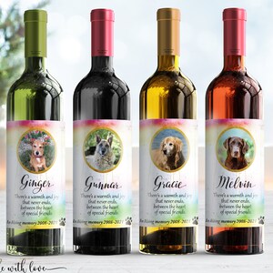 May include: Four wine bottles with personalized labels featuring dog photos and the text "There's a warmth and joy that never ends, between the heart of special friends." Each label has a different dog breed and name: Ginger, Gunnar, Gracie, and Melvin. The labels also include the years "2008-2021" in memory of the dogs.