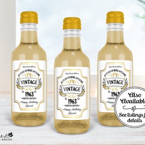 May include: Three small glass bottles with gold tops and white labels. The labels have a gold design and the text "40 Years of Being Awesome Vintage 1963 Limited Edition Happy Birthday Lauren!"