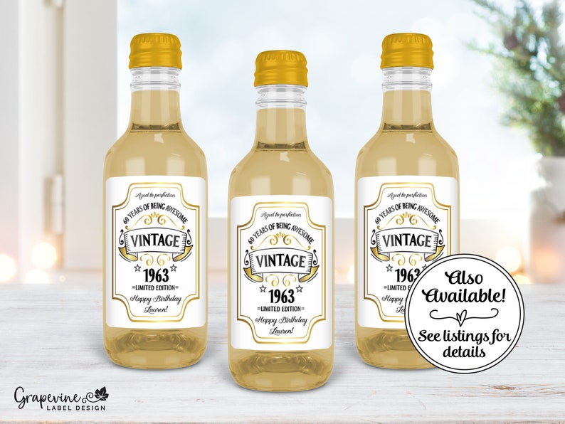 May include: Three small glass bottles with gold tops and white labels. The labels have a gold design and the text "40 Years of Being Awesome Vintage 1963 Limited Edition Happy Birthday Lauren!"