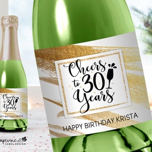 May include: A champagne bottle label with a gold glitter background and the text "Cheers to 30 Years" in black script. The label also includes the text "Happy Birthday Krista".