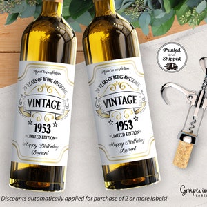 May include: Two white wine bottle labels with gold text. The labels say "Aged to perfection 70 Years of Being Awesome Vintage 1953 Limited Edition Happy Birthday Lauren!"