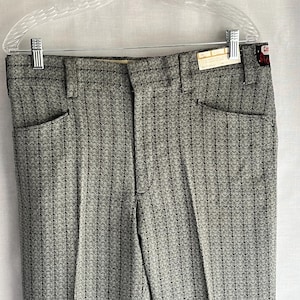 以下が含まれることがあります： 透明なハンガーに掛けられた、グレーと黒の模様のパンツ。 パンツはテクスチャード加工のデザインで、バックポケットが2つあります。 タグがパンツに付いています。 パンツは織物です。