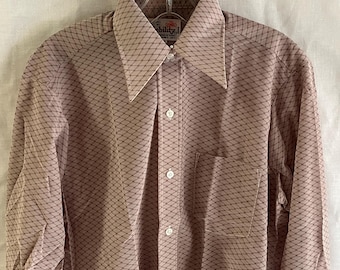 May include: A long-sleeved, pink button-down shirt with a geometric pattern. The shirt has a small pocket on the left chest and a white label with the text "Ability" on the collar.