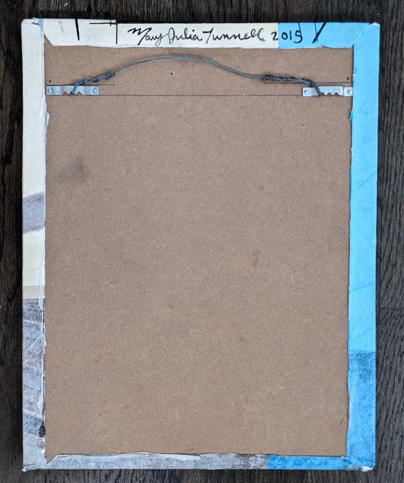 Puede incluir: La parte posterior de una obra de arte enmarcada con un borde azul claro. El marco es de madera y tiene un respaldo de cart&oacute;n marr&oacute;n. La firma del artista, "Mary Julia Tunnell 2015", est&aacute; escrita con tinta negra en la esquina superior derecha.