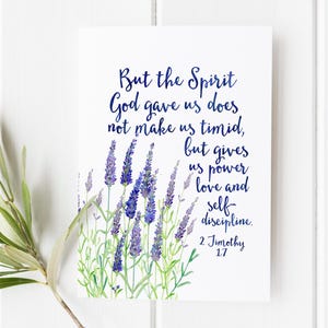 May include: A white print featuring a watercolor design of lavender and text in navy blue. The text reads: "But the Spirit God gave us does not make us timid, but gives us power love and self-discipline. 2 Timothy 1:7."