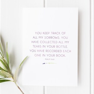 May include: A white card with a purple text quote from Psalm 56:8. The quote reads "You keep track of all my sorrows. You have collected all my tears in your bottle. You have recorded each one in your book."