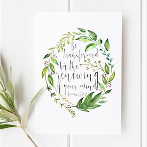 Pode incluir: Uma ilustração em aquarela de uma coroa de folhas com a citação "Sede transformados pela renovação da vossa mente" e a referência bíblica "Romanos 12:2".