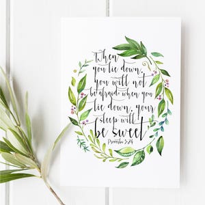 May include: A watercolor illustration of a leafy wreath with the quote "When you lie down, you will not be afraid. When you lie down, your sleep will be sweet. Proverbs 3:24" in black calligraphy.