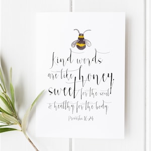 May include: A white card with black calligraphy that reads "Kind words are like honey, sweet for the soul & healthy for the body. Proverbs 16:24". A watercolour illustration of a bee is above the text.