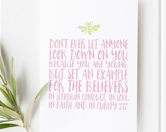 May include: A white card with pink text and a green bee illustration. The text reads, "Don't ever let anyone look down on you because you are young, but set an example for the believers..." A sprig of greenery is in the corner.