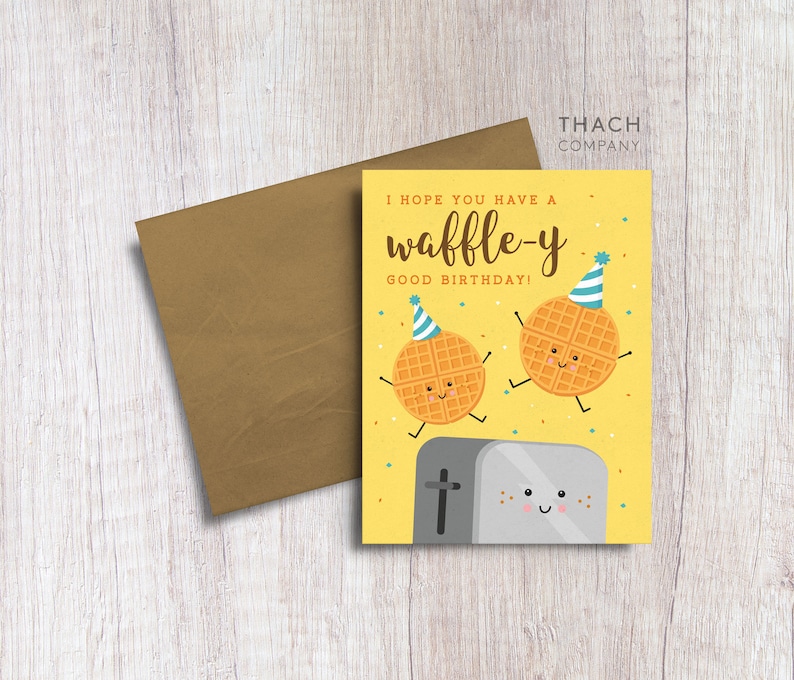 May include: A yellow birthday card with a waffle wearing a party hat and the text "I hope you have a waffle-y good birthday!"