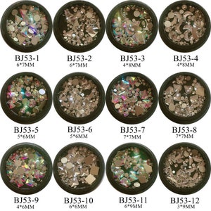 Puede incluir: Una colección de doce pequeños recipientes negros redondos llenos de pedrería iridiscente de varias formas. Cada recipiente está etiquetado con un código y medidas, como "BJ53-1 6*7MM". La pedrería es transparente y refleja múltiples colores.
