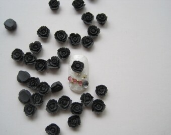May include: Black 3D rose nail charms, scattered on a white surface. The charms are small and delicate, perfect for adding a touch of elegance to your nail art.