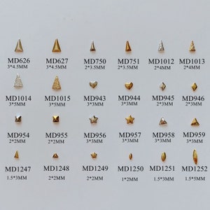 May include: A collection of small, metallic nail art studs in various shapes, including triangles, hearts, squares, stars, and diamonds. Sizes range from 1mm to 5mm. Each stud is labeled with a unique code.