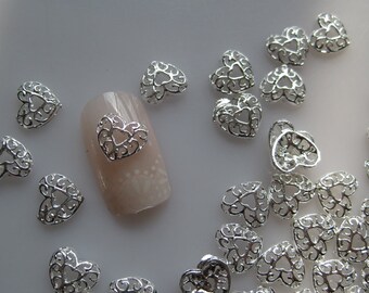 May include: Silver filigree heart nail charms. The charms are small and delicate, with a intricate design. They are perfect for adding a touch of sparkle to your nails.