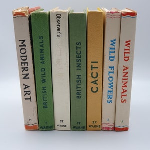 May include: A row of seven vintage paperback books with colorful covers and titles like "British Wild Animals", "Modern Art", and "Cacti".