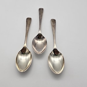 Può includere: Tre cucchiaini d'argento con ciotole arrotondate e manici semplici.