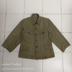 May include: Olive green jacket with four front pockets and button closures. The jacket has a collared neckline and long sleeves. The text "archive99culture" is visible in the lower left corner, along with the date and location.