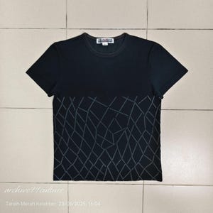 May include: Black short-sleeved t-shirt with a geometric pattern on the lower half. The shirt has a crew neck and a small label at the neckline. The geometric design is a series of gray lines forming diamond shapes.