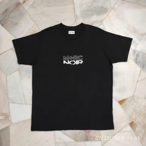 Camiseta de cuello redondo con logo triste y roto "Marché Noir" de M+RC NOIR Aw19