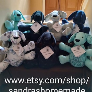 May include: A collection of eight handmade plush dog toys in various colors and patterns, including blue, black, white, and floral. The toys are arranged on a dark surface with the text "www.etsy.com/shop/sandrashomemade" visible at the bottom of the image.